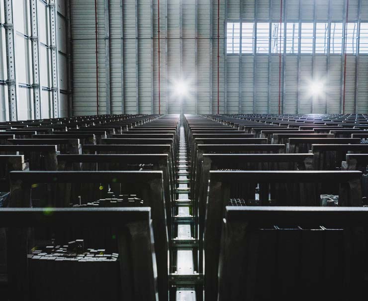 Blick in ein modernes Hochregallager von Heseding mit dicht bef&uuml;llten Regalen voller Flach-, Rund- und Winkelprofile aus Metall &ndash; professionelle Lagerlogistik und gro&szlig;e Auswahl an Messingprofilen f&uuml;r den zuverl&auml;ssigen Einsatz im Handwerk und in der Industrie.